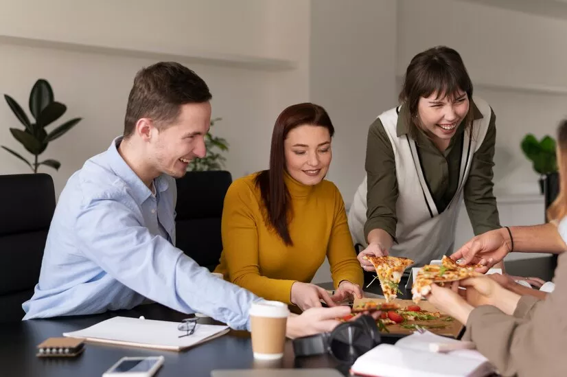 Empleados felices comiendo juntos en la hora de su almuerzo con su beneficio ticket de alimentación. ¿Ya pensaste en como hacer felices a tus empleados? Una forma fácil es ofrecerles beneficios. Lee este artículo y conocé más como los beneficios Pluxee pueden ayudarte a aumentar la productividad laboral de tu equipo. 