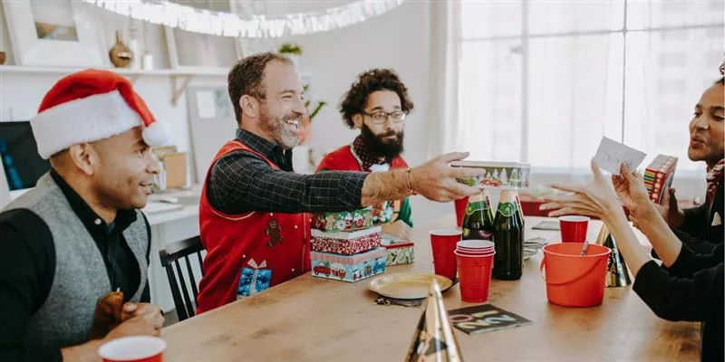 Grupo de colaboradores intercambiando regalos del amigo invisible de navidad 