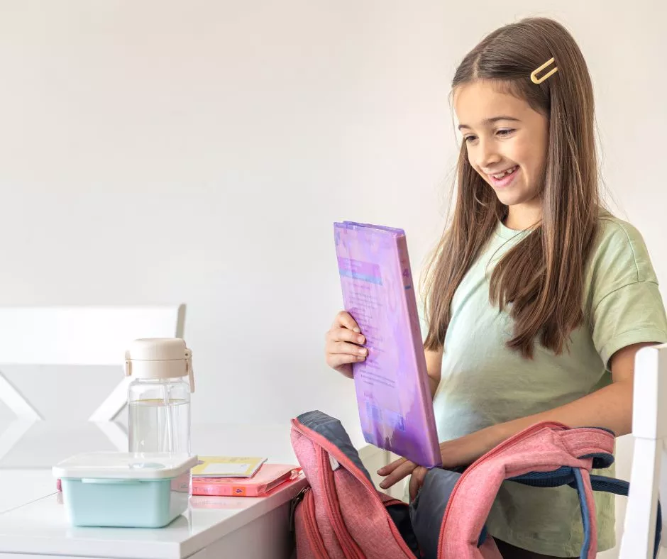 Niña en edad escolar con un set de útiles escolares nuevo 