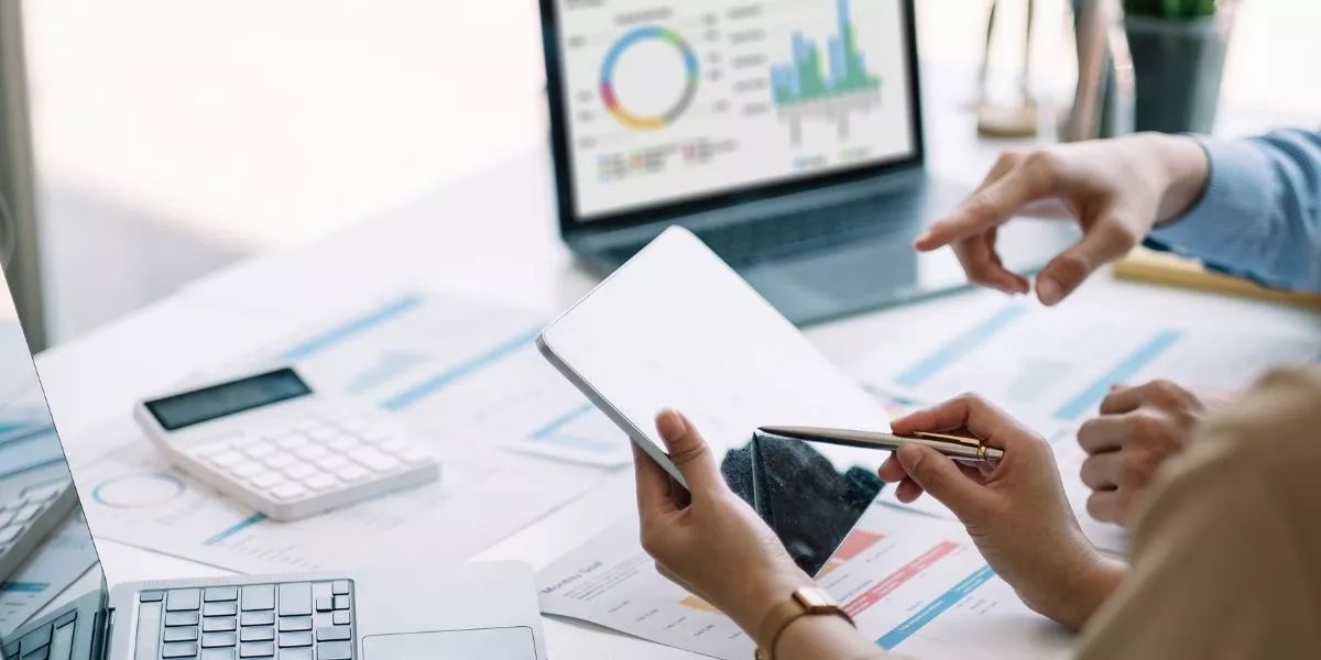 Colaboradores analizando datos en dispositivos digitales durante una capacitación sobre inteligencia artificial.