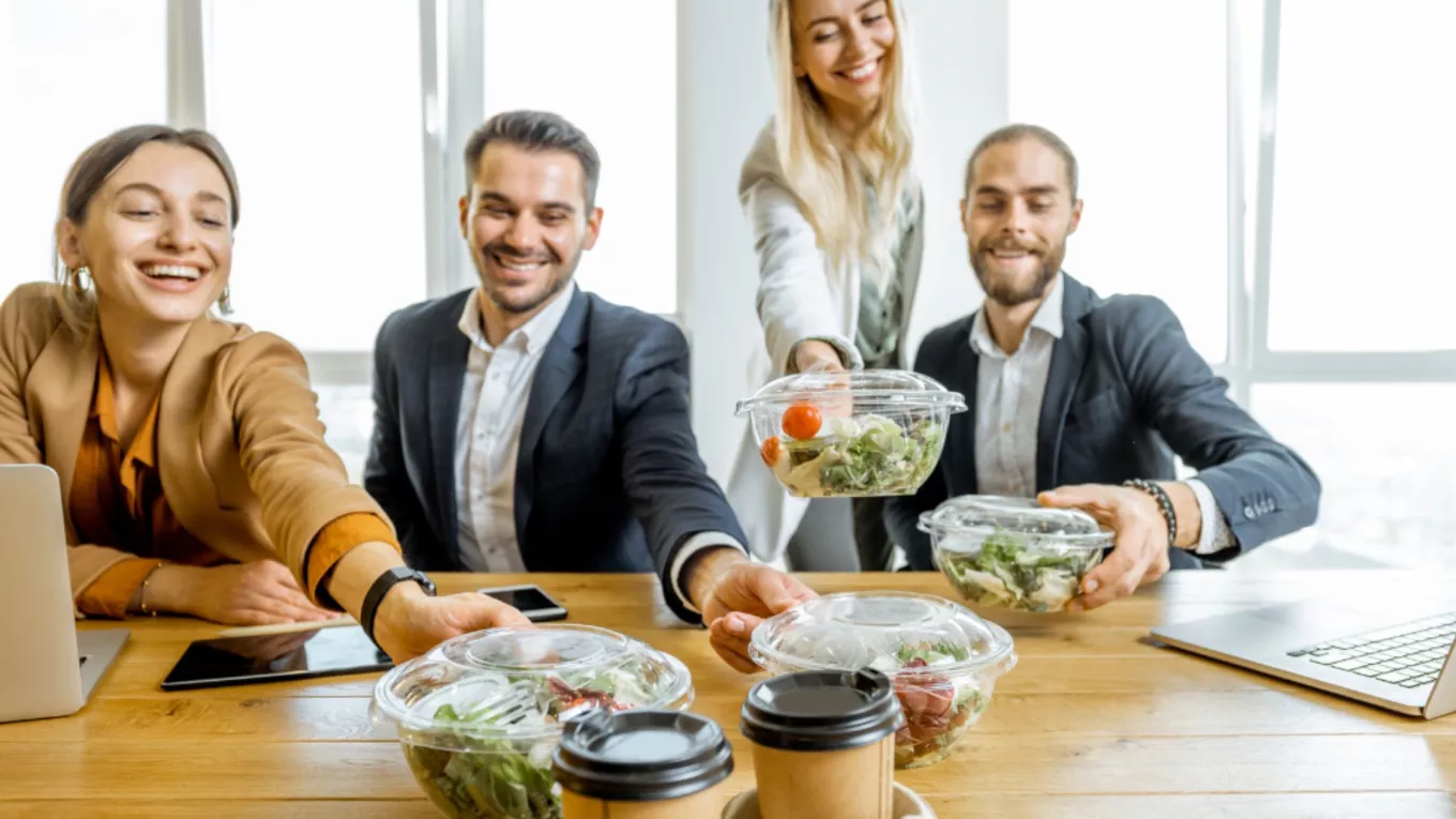 Colaboradores en la oficina compartiendo de una comida saludable en el trabajo