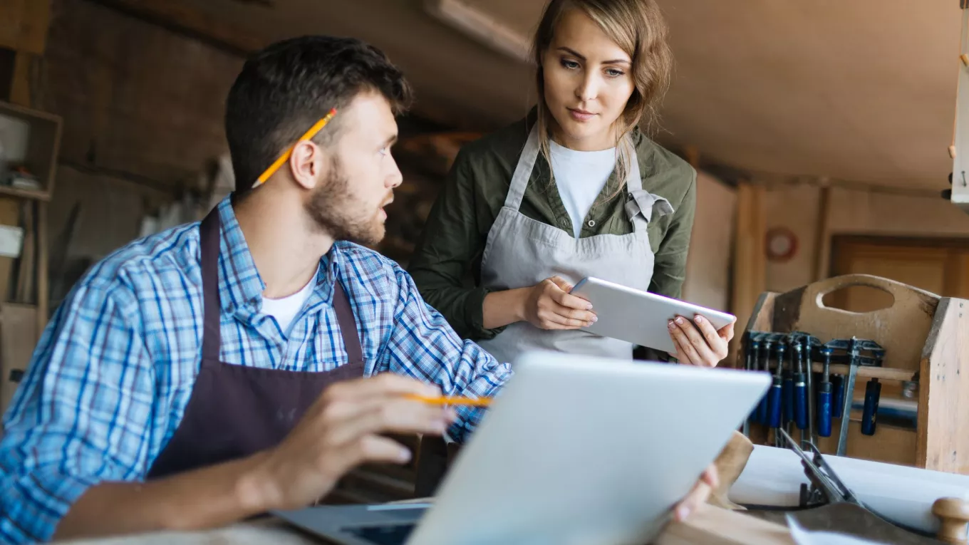 Colaboradores de una pyme en Uruguay trabajando con una computadora y una tablet.