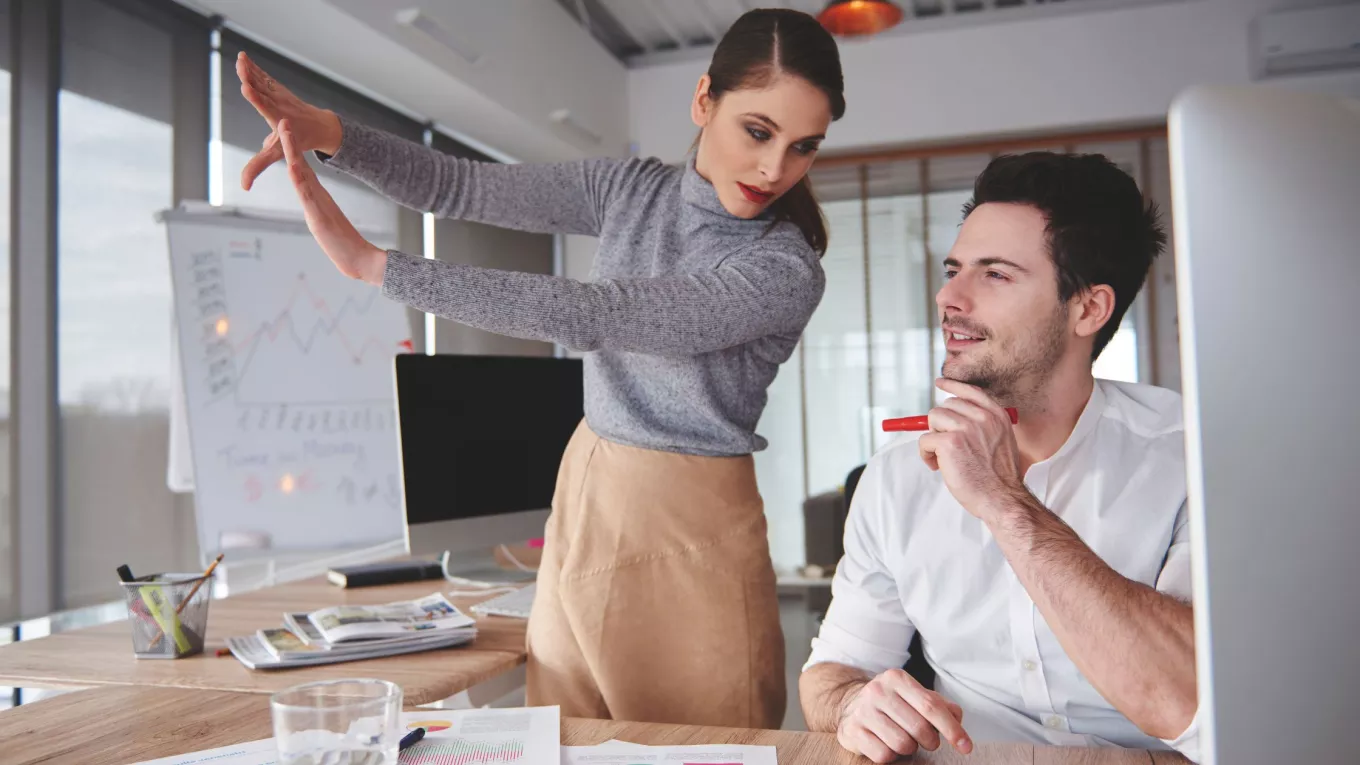 Líderes de gestión humana colaboran frente a una computadora para preparar a sus equipos ante el futuro del trabajo. 