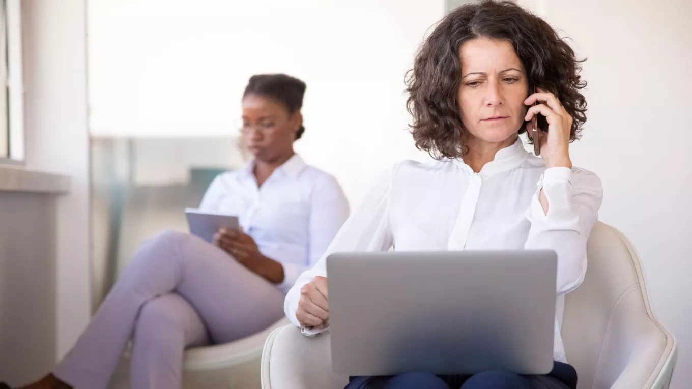 Mujer atiende una llamada frente a una computadora, en una escena que ilustra los desafíos de la desconexión digital.