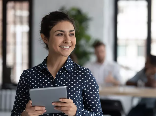 Profesional utilizando una tablet en oficina moderna, aplicando la Guía gratuita: 50 prompts de IA para expertos en RRHH en tareas de gestión y desarrollo organizacional.