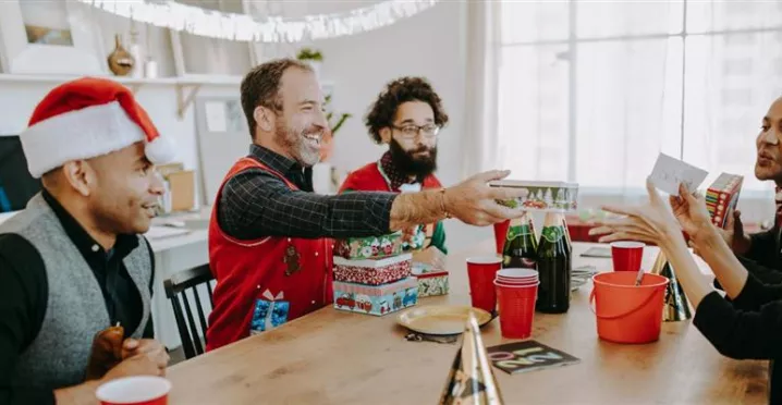 Grupo de colaboradores intercambiando regalos del amigo invisible de navidad