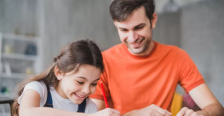 Padre e hija realizando tareas escolares en casa, imagen asociada a sodexo útiles escolares y a la gestión de la vuelta a clases en las empresas.