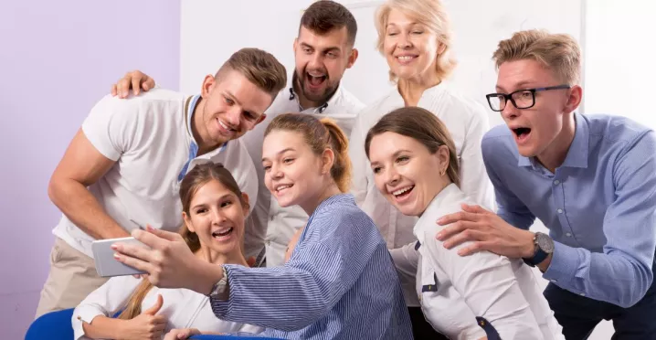 Jóvenes profesionales en el trabajo compartiendo en equipo, ejemplo de ambiente laboral flexible en Uruguay