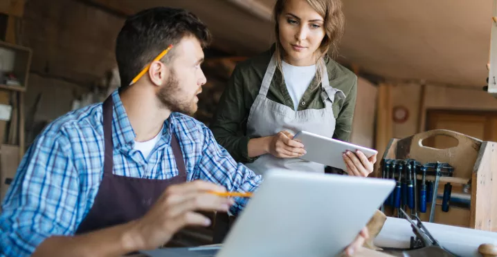 Colaboradores de una pyme en Uruguay trabajando con una computadora y una tablet.