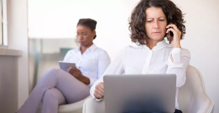 Mujer atiende una llamada frente a una computadora, en una escena que ilustra los desafíos de la desconexión digital.