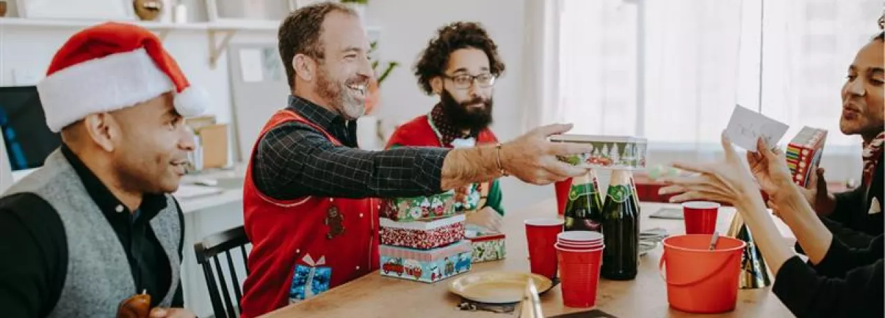 Grupo de colaboradores intercambiando regalos del amigo invisible de navidad