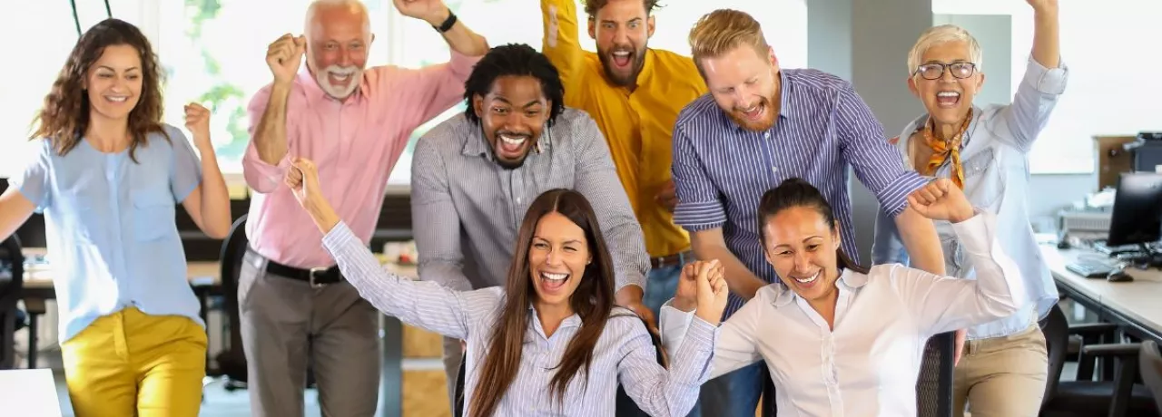 Equipo de trabajo celebrando juntos en la oficina durante una actividad de team building.