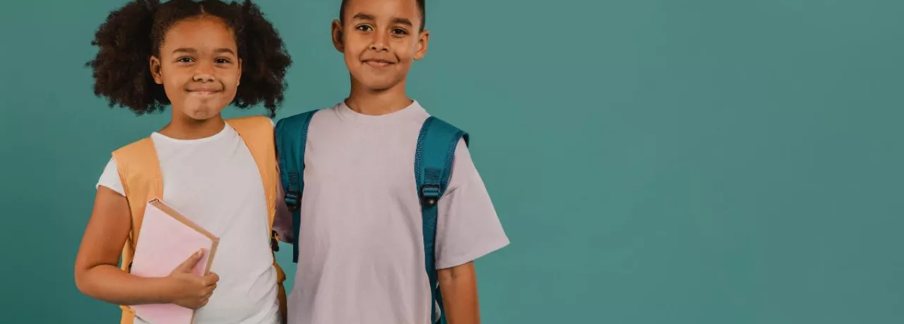Niños con mochilas y útiles escolares, representando la vuelta a clases y su impacto en las familias.