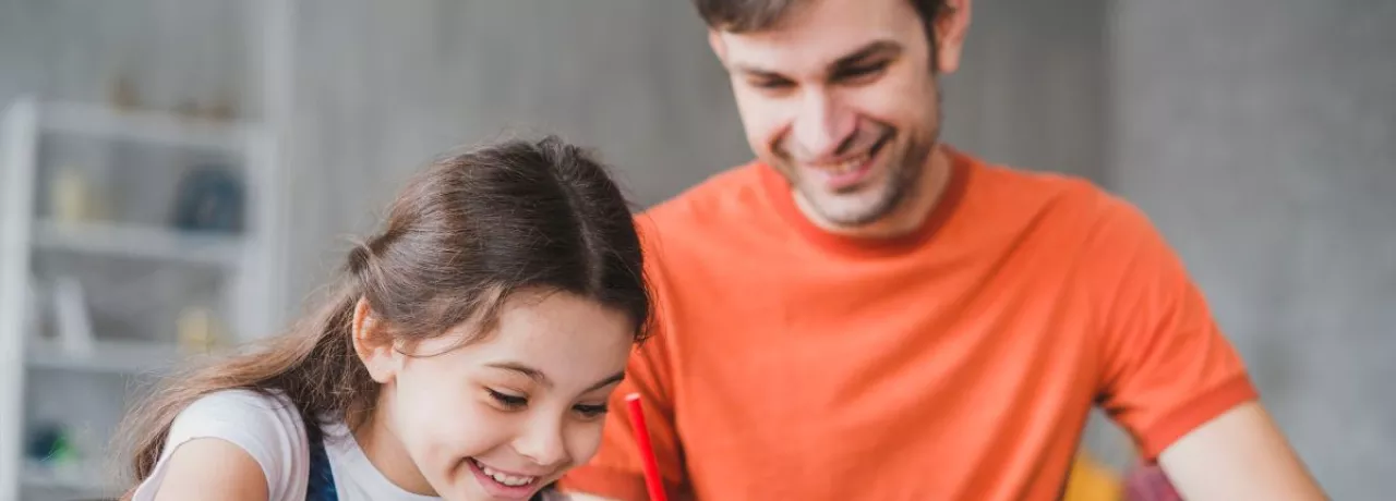Padre e hija realizando tareas escolares en casa, imagen asociada a sodexo útiles escolares y a la gestión de la vuelta a clases en las empresas.