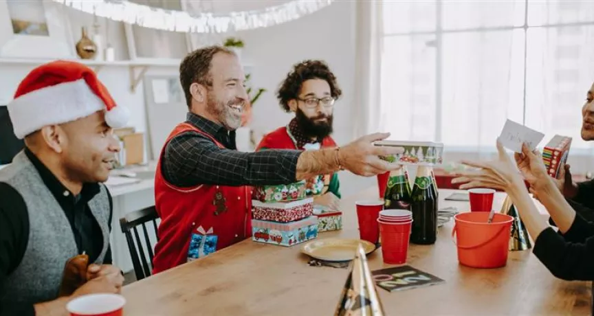 Grupo de colaboradores intercambiando regalos del amigo invisible de navidad
