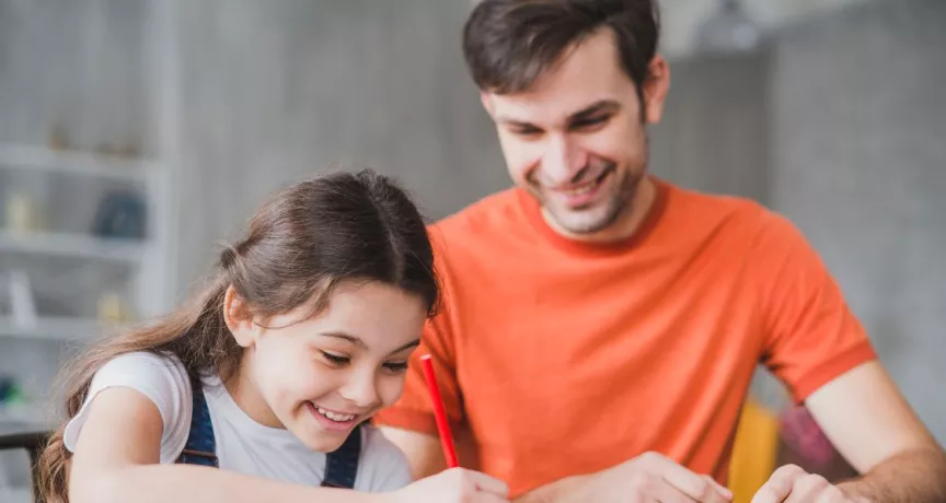 Padre e hija realizando tareas escolares en casa, imagen asociada a sodexo útiles escolares y a la gestión de la vuelta a clases en las empresas.