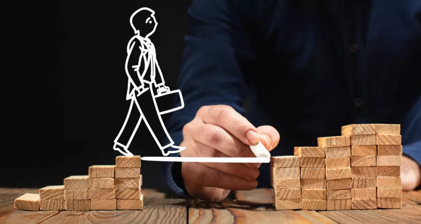 Plan de desarrollo profesional representado con bloques y figura avanzando en carrera laboral