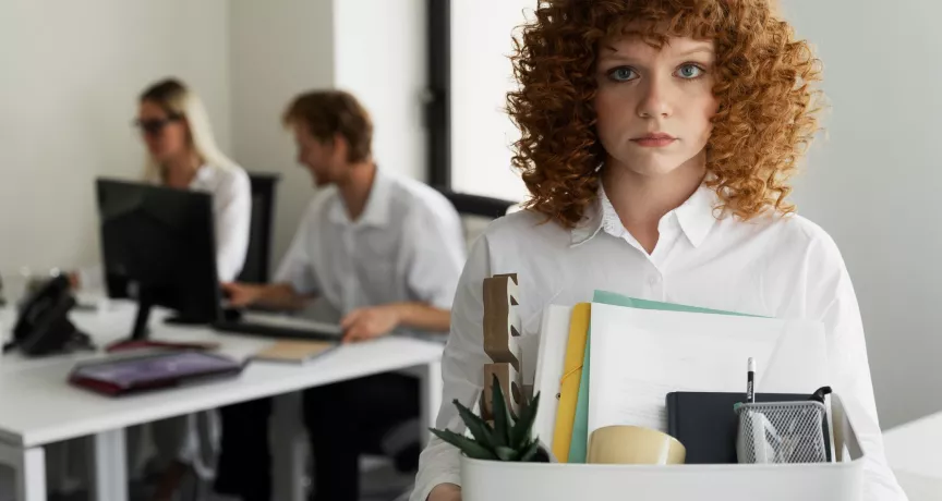 Colaboradora dejando la oficina con sus pertenencias tras una renuncia laboral vinculada a la rotación de personal en empresas.