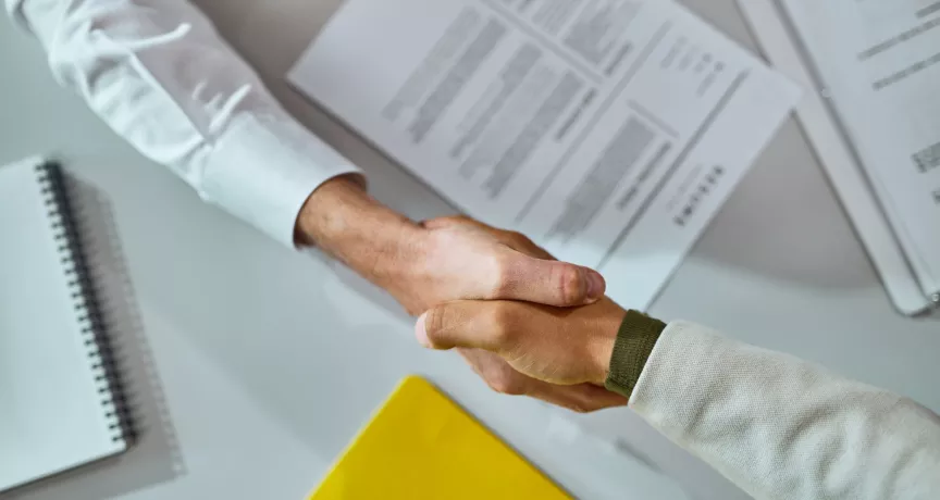 Persona estrechando la mano de un colaborador durante un proceso de offboarding en una oficina.
