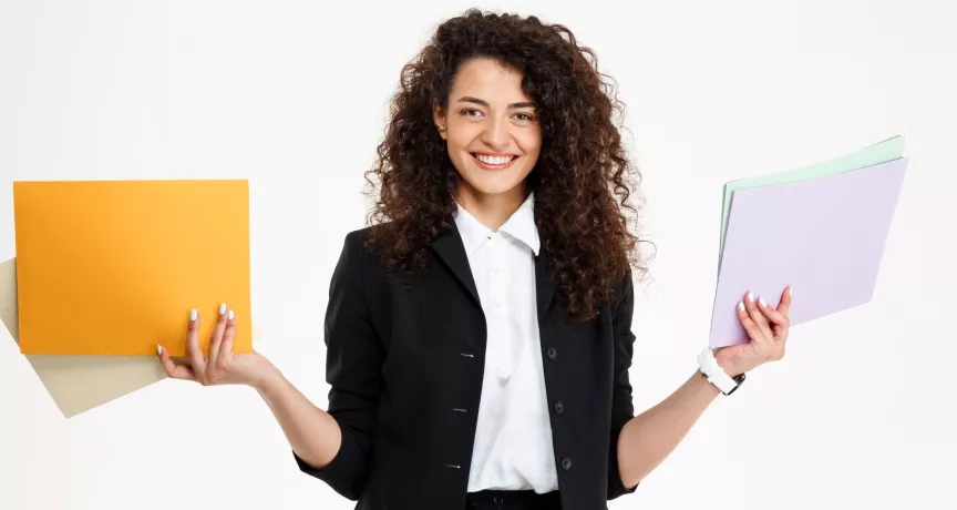 Mujer profesional con carpetas en ambas manos, en referencia al pluriempleo y a tener dos trabajos.