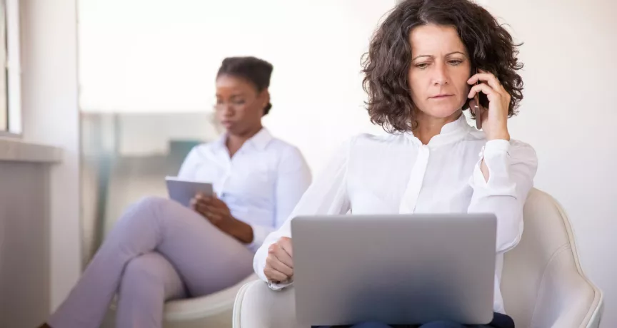 Mujer atiende una llamada frente a una computadora, en una escena que ilustra los desafíos de la desconexión digital.