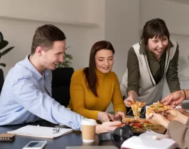 Empleados felices comiendo juntos en la hora de su almuerzo con su beneficio ticket de alimentación. ¿Ya pensaste en como hacer felices a tus empleados? Una forma fácil es ofrecerles beneficios. Lee este artículo y conocé más como los beneficios Pluxee pueden ayudarte a aumentar la productividad laboral de tu equipo.