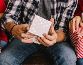 Manos de personas con regalos comprados con Pluxee Navidad