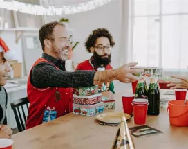 Grupo de colaboradores intercambiando regalos del amigo invisible de navidad