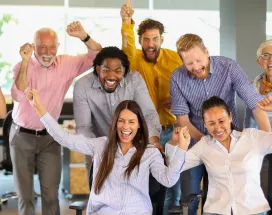 Equipo de trabajo celebrando juntos en la oficina durante una actividad de team building.
