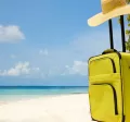 Valija sobre la arena frente al mar, representando el descanso y las vacaciones laborales.