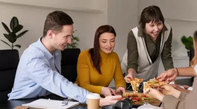 Empleados felices comiendo juntos en la hora de su almuerzo con su beneficio ticket de alimentación. ¿Ya pensaste en como hacer felices a tus empleados? Una forma fácil es ofrecerles beneficios. Lee este artículo y conocé más como los beneficios Pluxee pueden ayudarte a aumentar la productividad laboral de tu equipo.