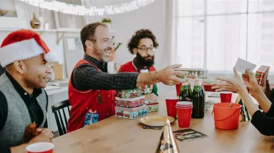 Grupo de colaboradores intercambiando regalos del amigo invisible de navidad