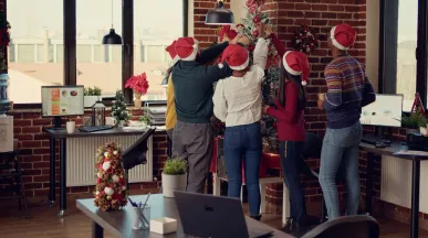 Equipo de trabajadores decorando juntos el árbol de navidad de la oficina