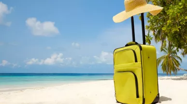 Valija sobre la arena frente al mar, representando el descanso y las vacaciones laborales.