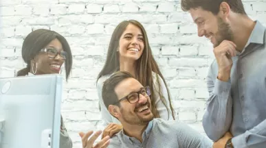 Equipo de colaboradores conversando y trabajando juntos en una oficina, representando el compromiso y la retención del personal en las empresas.