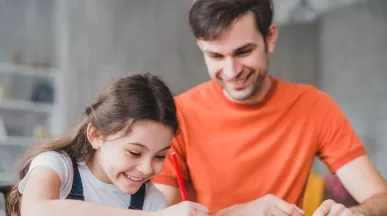 Padre e hija realizando tareas escolares en casa, imagen asociada a sodexo útiles escolares y a la gestión de la vuelta a clases en las empresas.