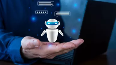 Persona sosteniendo un agente de inteligencia artificial virtual frente a una computadora, representando el uso de IA en Recursos Humanos para automatizar procesos.