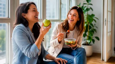 Colaboradoras disfrutando de un snack saludable en la oficina, gracias a la tarjeta de alimentación que les brinda su empresa.