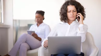 Mujer atiende una llamada frente a una computadora, en una escena que ilustra los desafíos de la desconexión digital.
