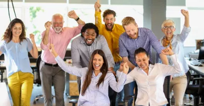 Equipo de trabajo celebrando juntos en la oficina durante una actividad de team building.