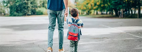 Padre lleva a su hijo a la escuela