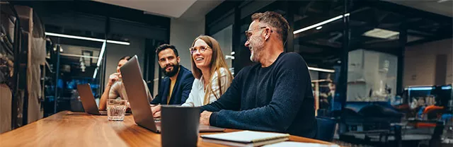 Tres profesionales participan en una reunión en una oficina.