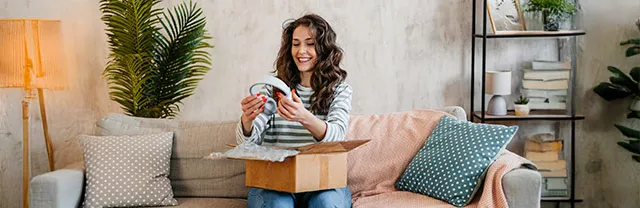 Mujer abriendo un regalo comprado con Pluxee Gift