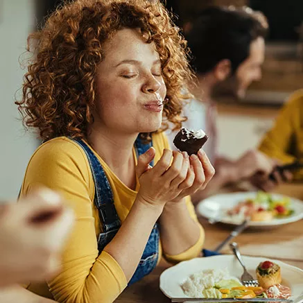 Mujer comiendo y disfrutando una comida